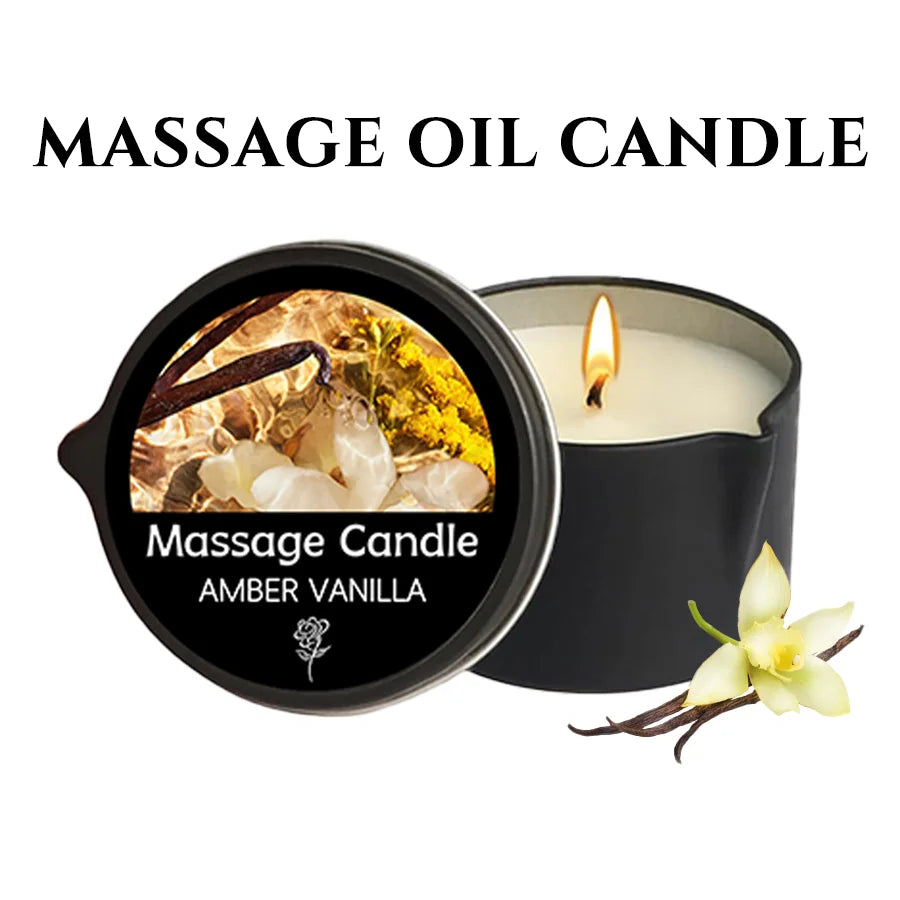 The candle in its black tin, lit, labelled amber vanilla, beside a vanilla flower