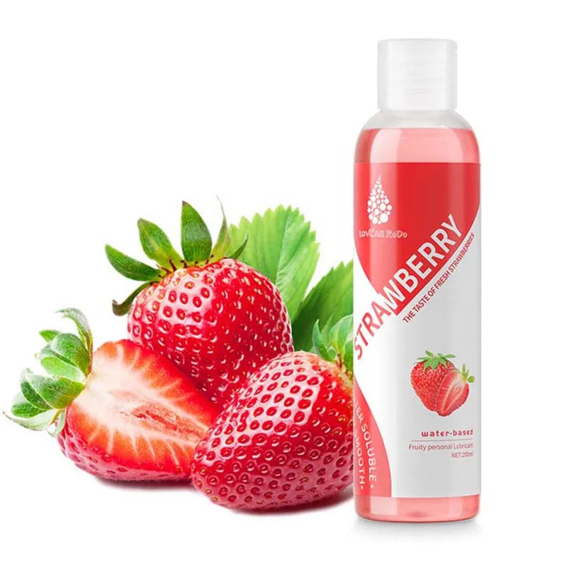 The strawberry lubricant bottle beside fresh strawberries
